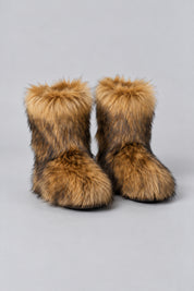 Bottes en moumoute marron, paire seule sur fond studio gris clair.