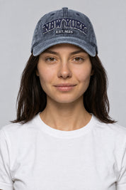 Casquette Rap Années 2000 — portée par notre modèle femme sur fond gris studio