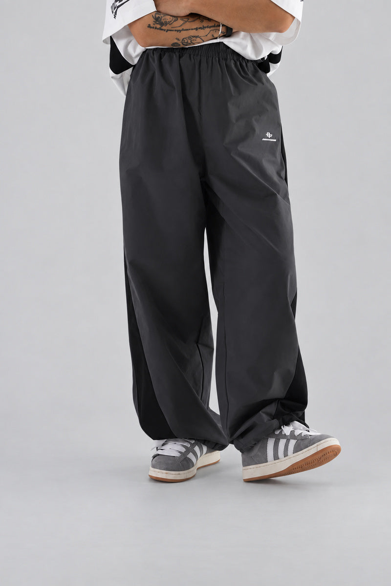 Jogging Y2K édition 'Shadow Sport', vue de trois quarts avant, sur fond studio gris clair.
