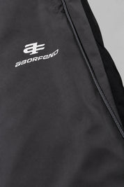 Jogging Y2K édition 'Shadow Sport', détail du logo, sur fond studio gris clair.