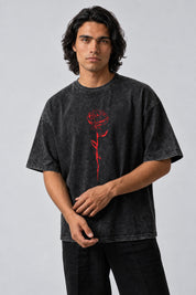 T-shirt oversize gris anthracite délavé avec rose rouge imprimée sur le devant, porté de face.