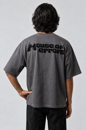 T-shirt gris oversize avec inscription noire « House of errors » en haut du dos.