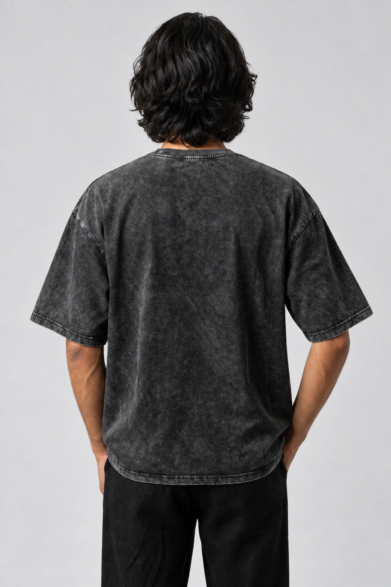Dos uni du t-shirt punk oversize gris anthracite délavé, porté sur fond gris perle.
